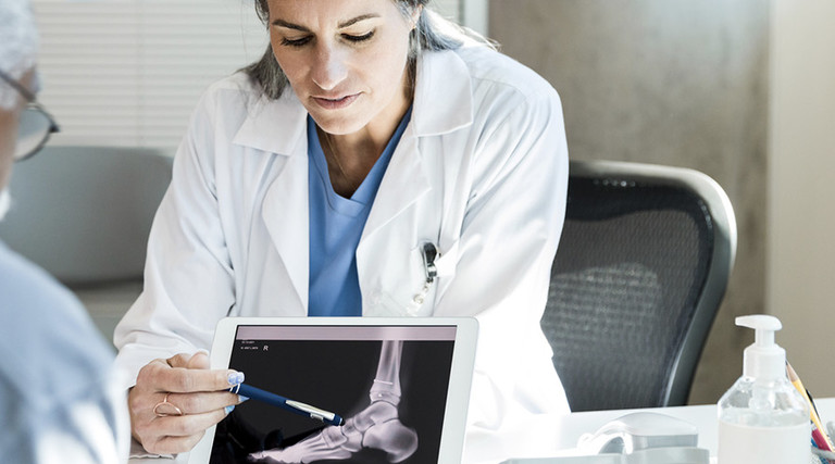 Doctor using tablet with patient 