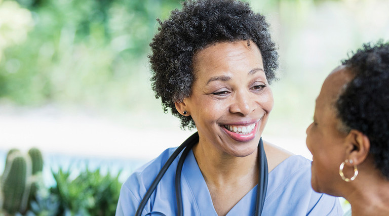 Nurse speaks to an older adult woman